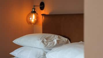 Una cama bien hecha con sábanas blancas y un cabecero de madera.