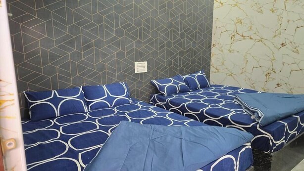 A room with two beds, each with blue bedding and geometric patterns. - Sree Guru Sannidhi A Budget Luxury Lodge (Mantralayam)