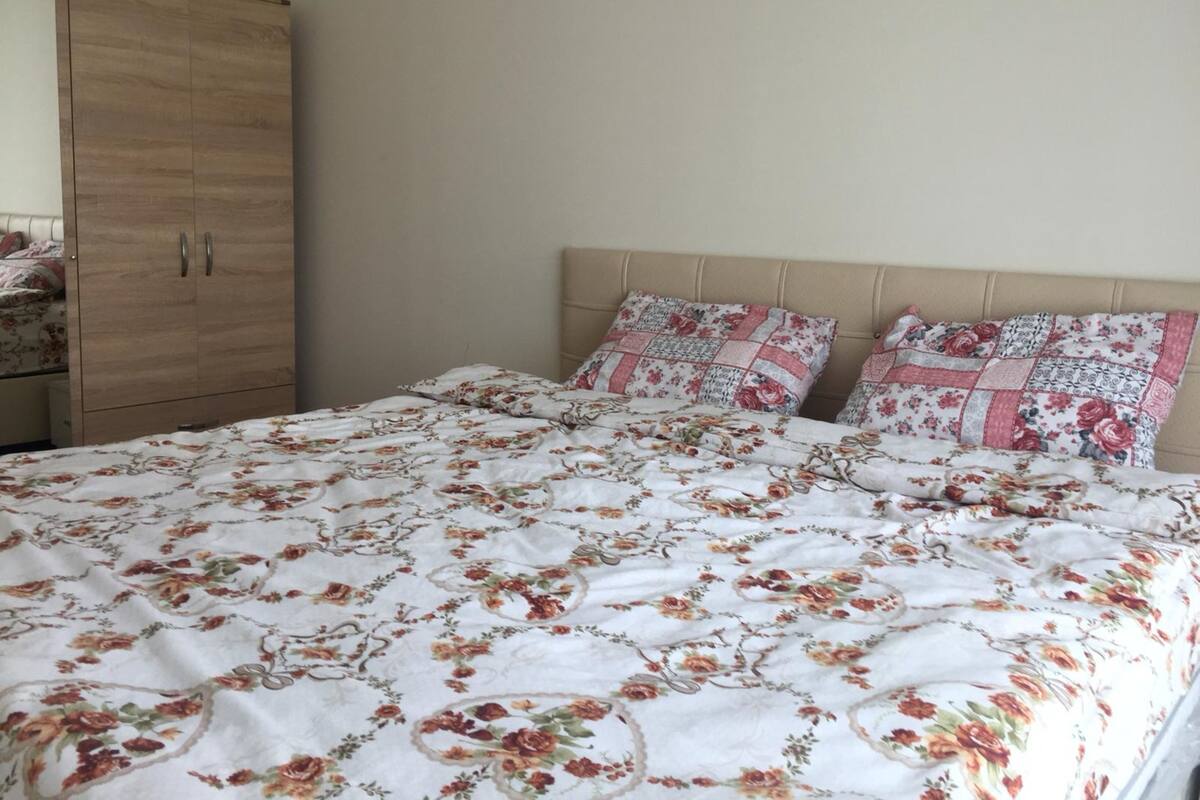 Une chambre à coucher avec un lit, deux oreillers, une armoire en bois et une tête de lit.