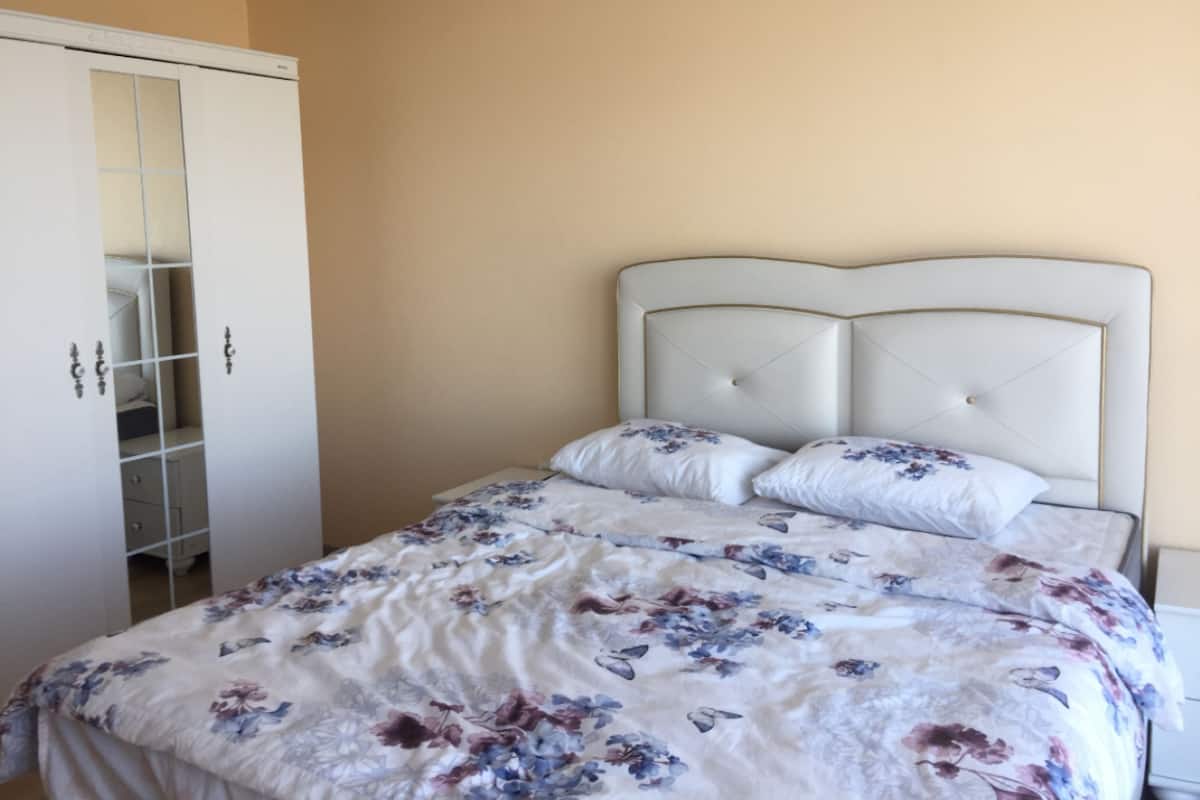 Une chambre à coucher avec un lit, une armoire et un miroir.