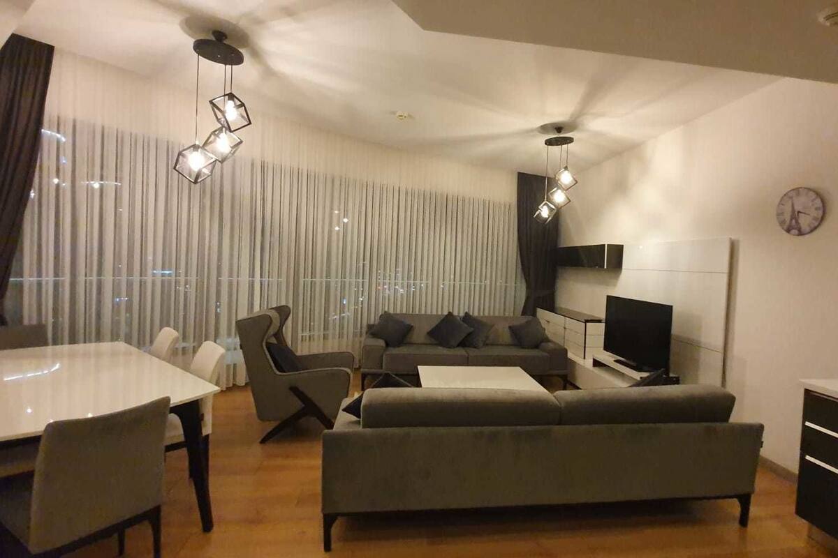 Un salon moderne comprenant un coin repas, un canapé et un téléviseur.