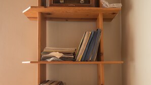 A wooden bookshelf with multiple shelves, some holding books and magazines. - Mosaic Home - Hostel (Tirana)