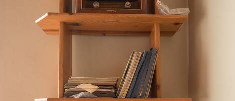 Una estantería de madera con varios estantes, algunos con libros y revistas.