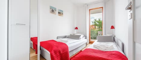 Un dormitorio moderno con dos camas, un espejo grande y vistas al exterior.