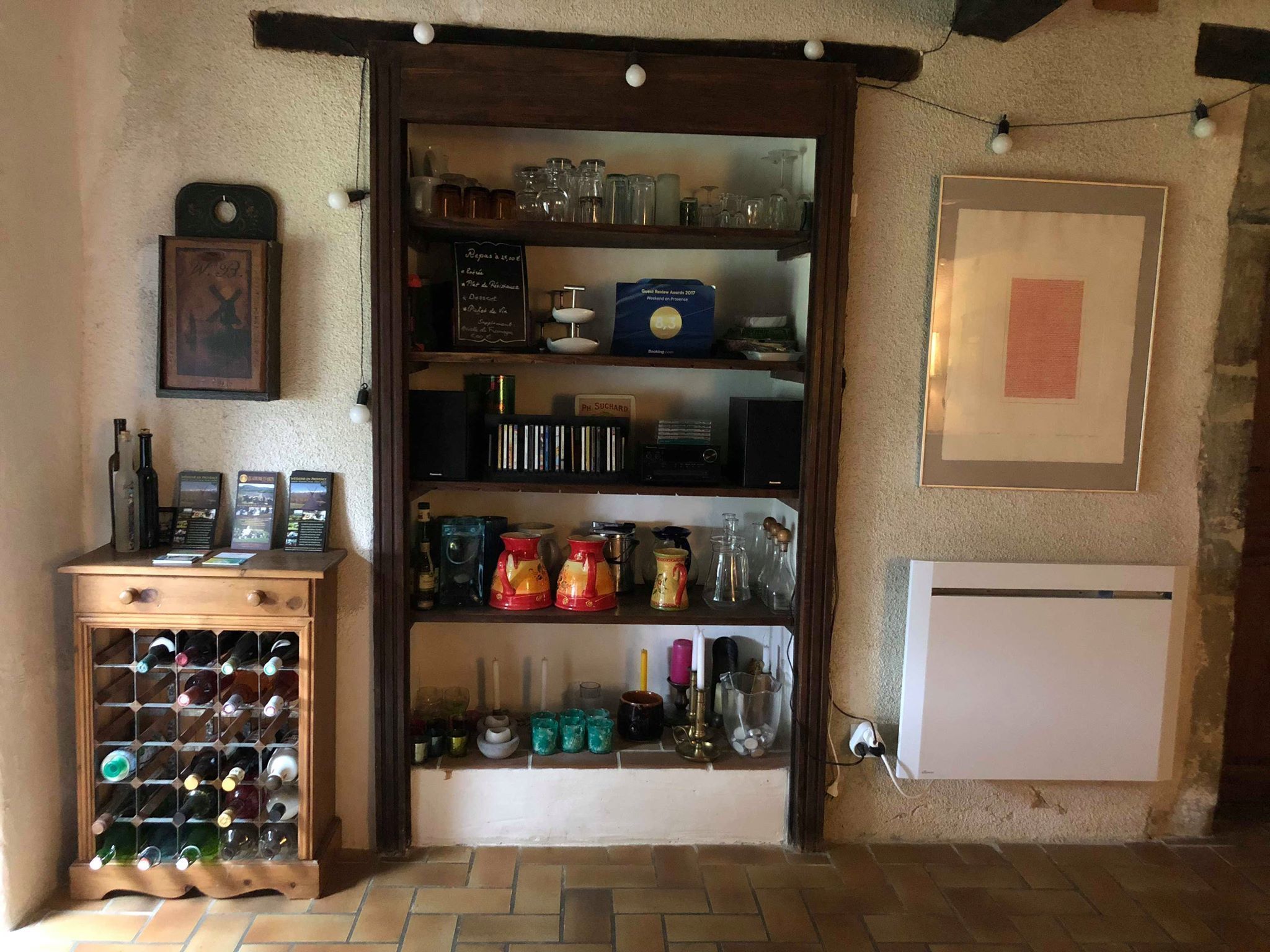 Une cave à vin avec des étagères remplies de bouteilles, un porte-bouteilles et divers types de verres.