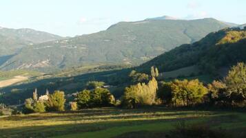 A mountainous landscape with rolling hills and scattered trees.