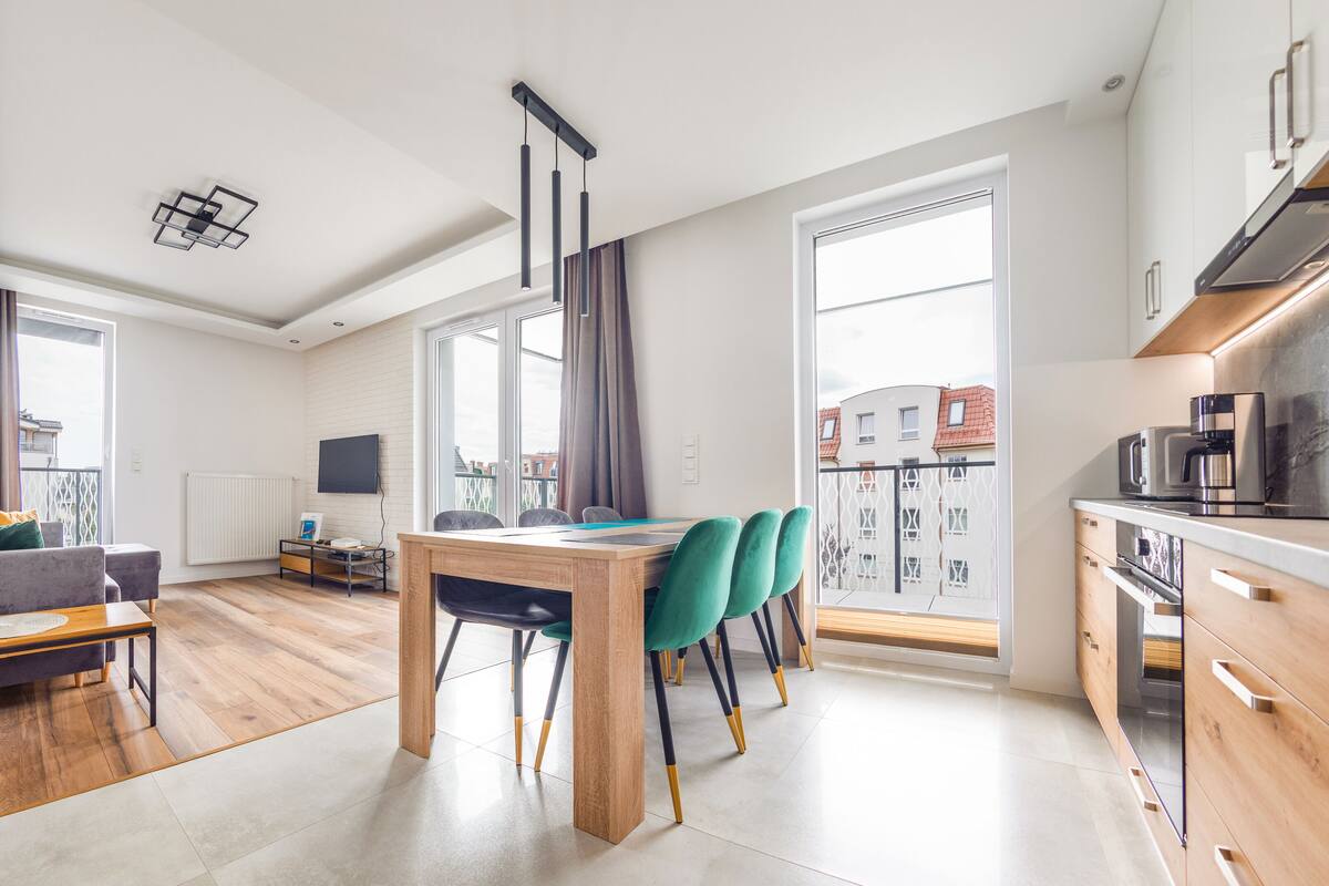 A modern apartment with a dining area, kitchen, and living space.