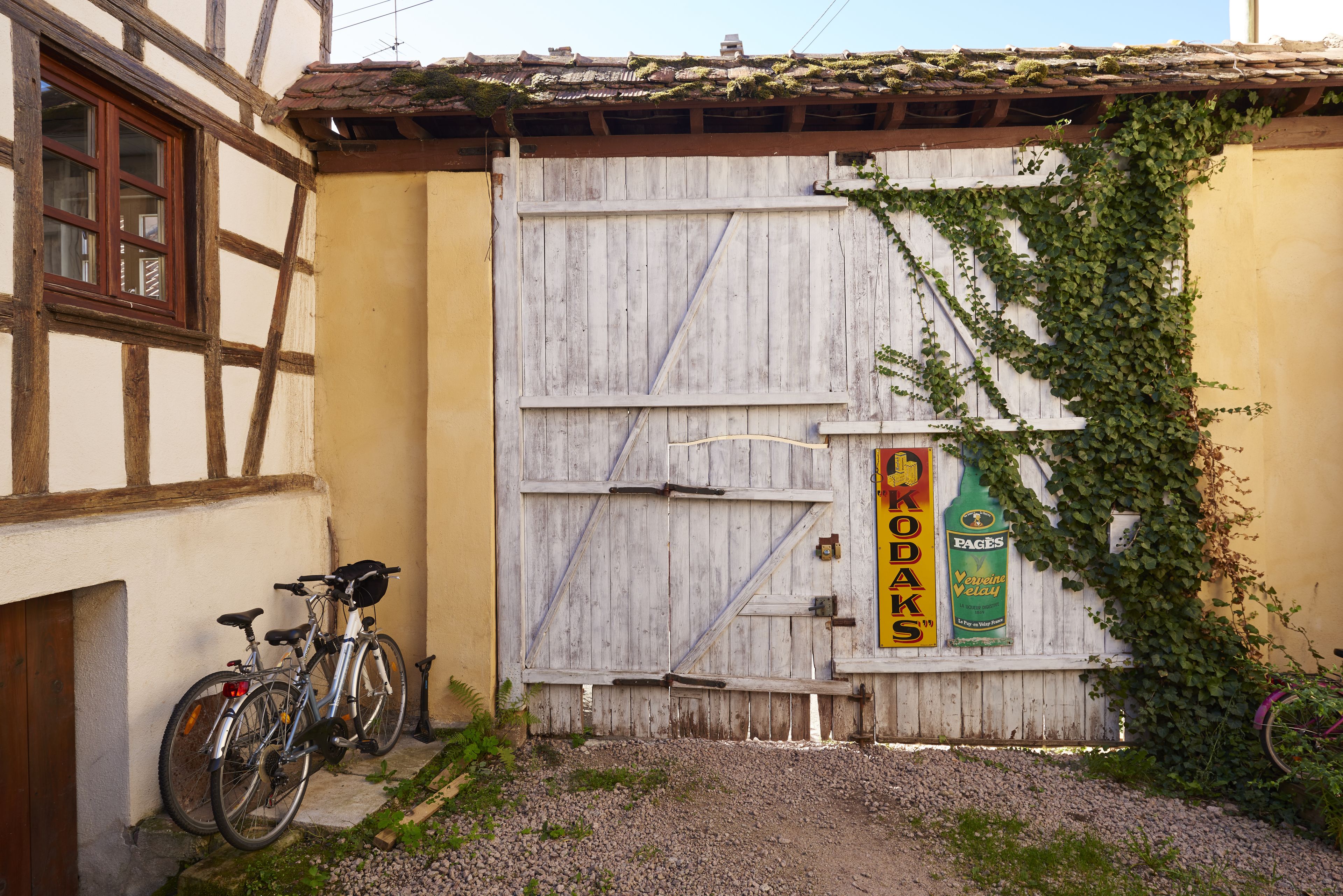 Een landelijke constructie met een houten deur en een fiets voor de deur.