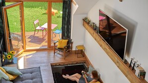 A modern interior with a large TV, a sofa, and a reading area with a net. - Un Soir d'Eté (Ernolsheim-Bruche)