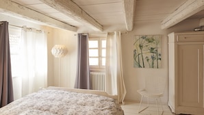 A bedroom with a bed, a radiator, a chair, and a painting on the wall. - Un Soir d'Eté (Ernolsheim-Bruche)
