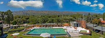 Una piscina al aire libre, sillones reclinables de piscina