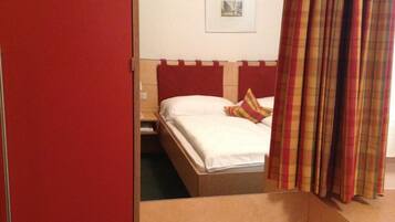 Una habitación de hotel con una cama, una mesita y un espejo.