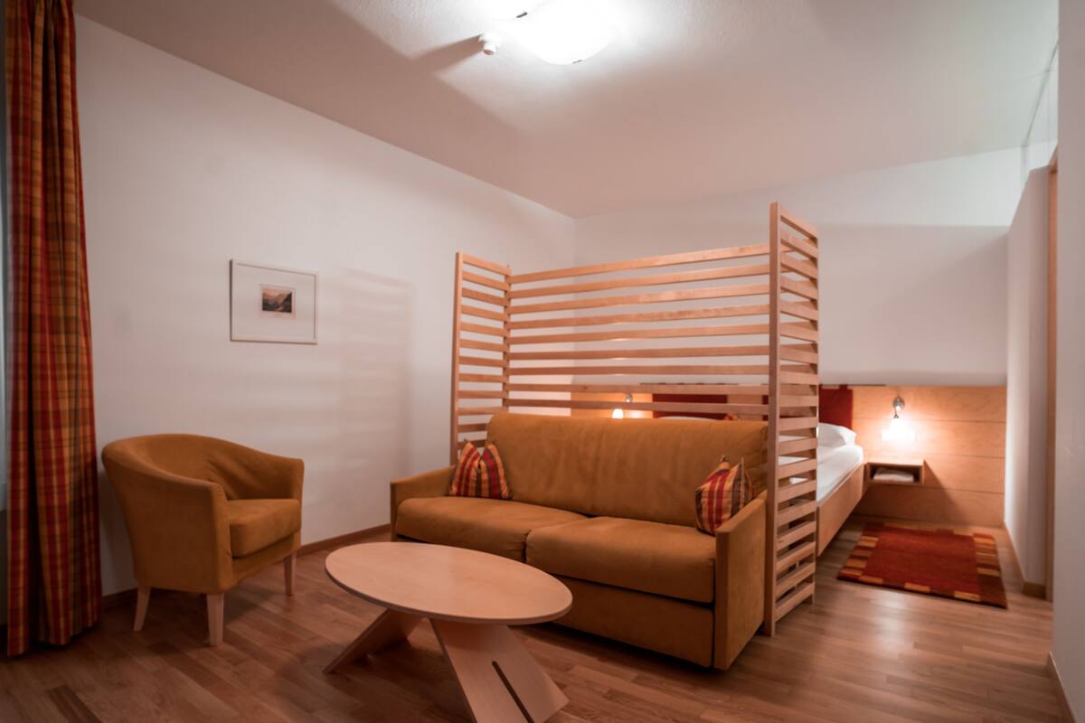 A modern living room with a sofa, armchair, and coffee table.