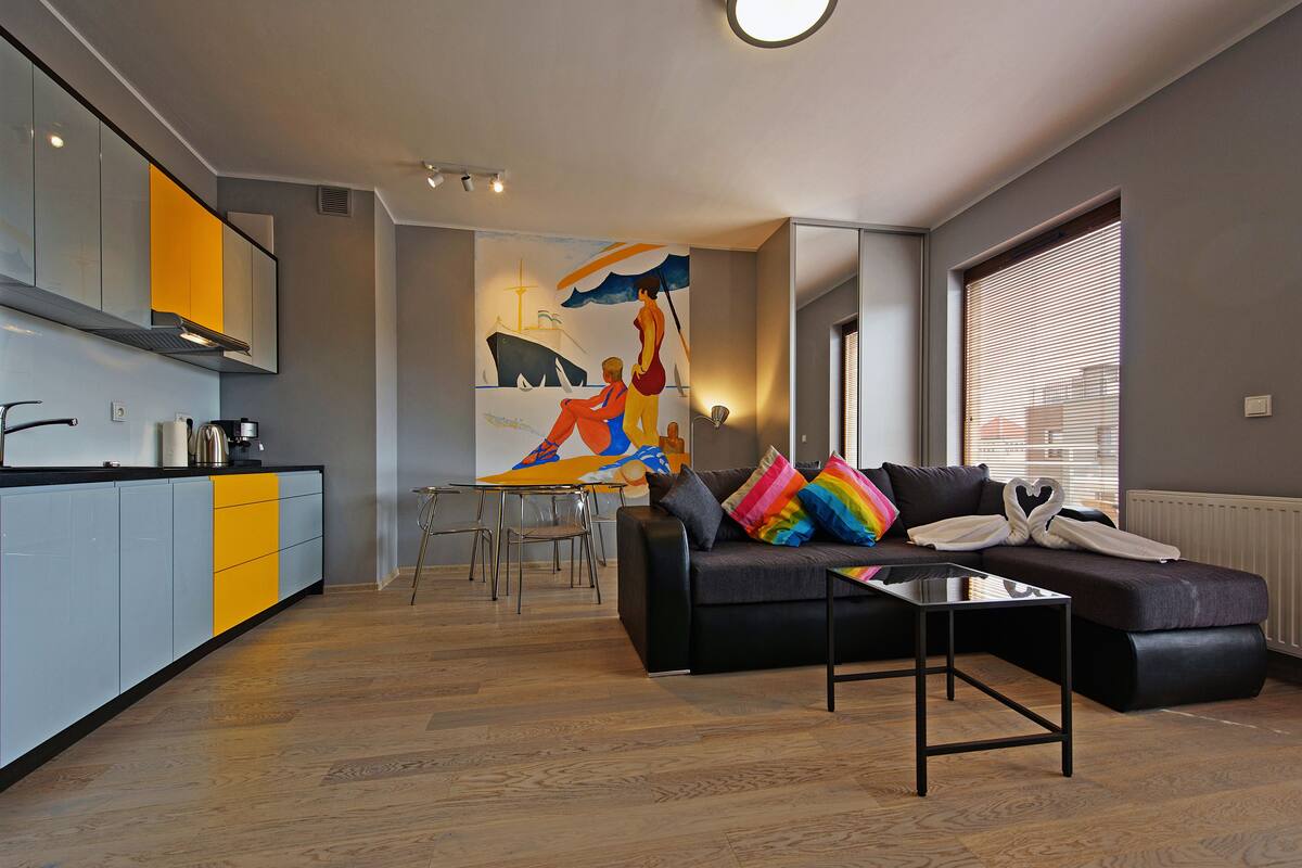 Un espace de vie moderne comprenant un canapé, une table basse et une table à manger avec des chaises.