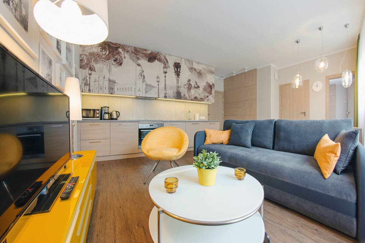 Un salon moderne avec un canapé, une table basse et un téléviseur.