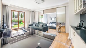 Un appartement moderne doté d’un balcon, d’une cuisine et d’un espace de vie comprenant un canapé et une table à manger.
