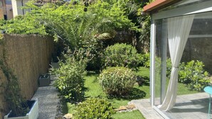 A garden with various plants and a small patio area. - Paradise Inn (Livorno)