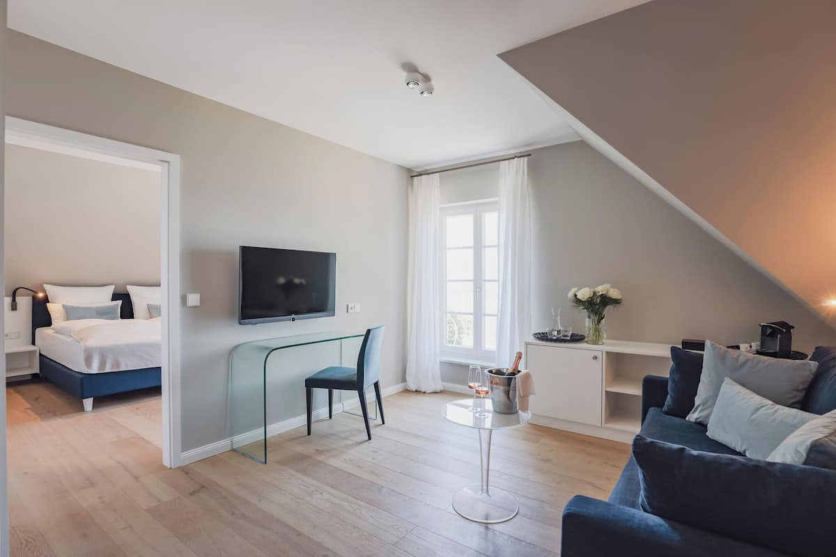 Ein modernes Wohnzimmer mit einem Bett, einem Fernseher, einem Esstisch mit einem Stuhl und einer Couch.