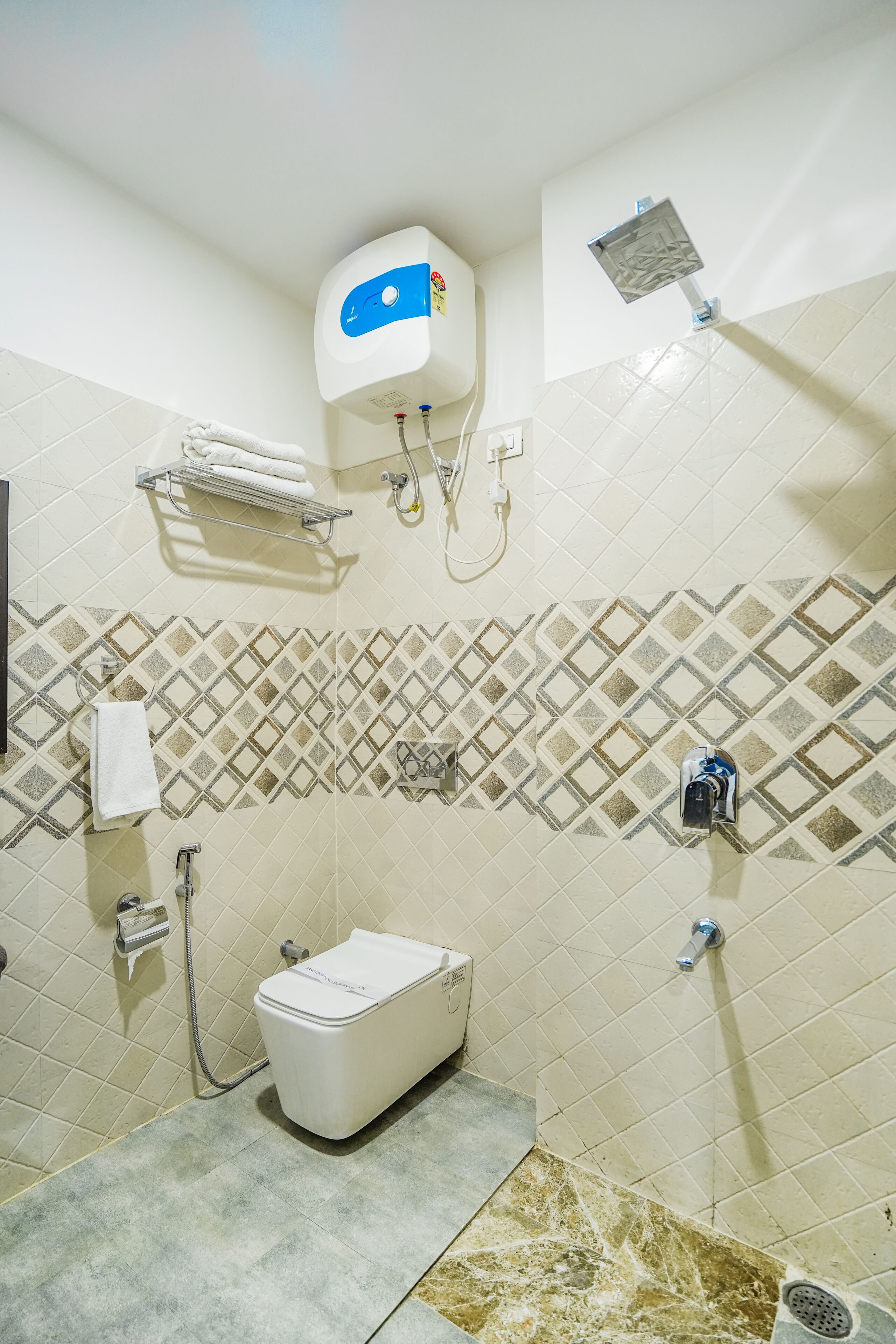 Une salle de bain avec douche, toilettes et porte-serviettes.