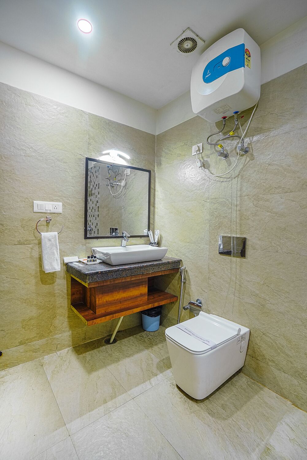 A bathroom with a sink, mirror, shower, and toilet.