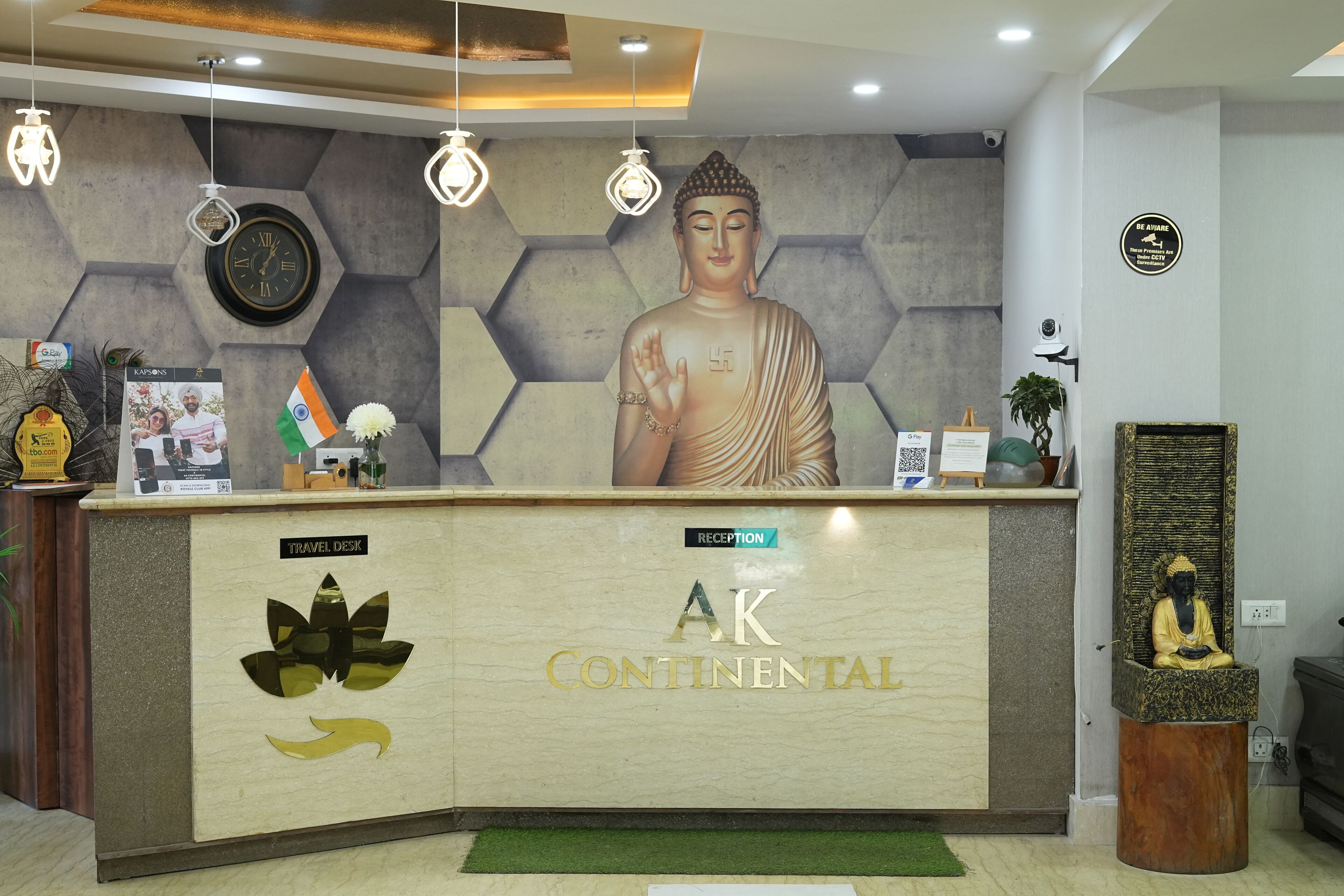 A reception desk with a Buddha statue, a clock, and a sign reading "AK Continental."