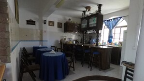 Cocina con comedor, que incluye una barra, mostrador y taburetes.