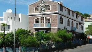 Un edificio de dos plantas con fachada de piedra y un balcón.