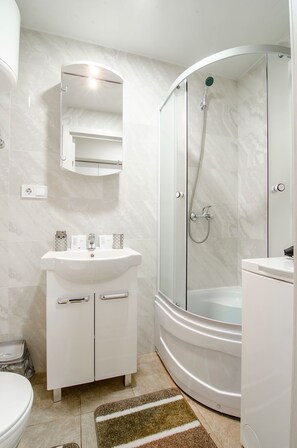 Chambre quadruple Standard | Salle de bain | Douche, articles de toilette (gratuits), séchoir à cheveux, pantoufles