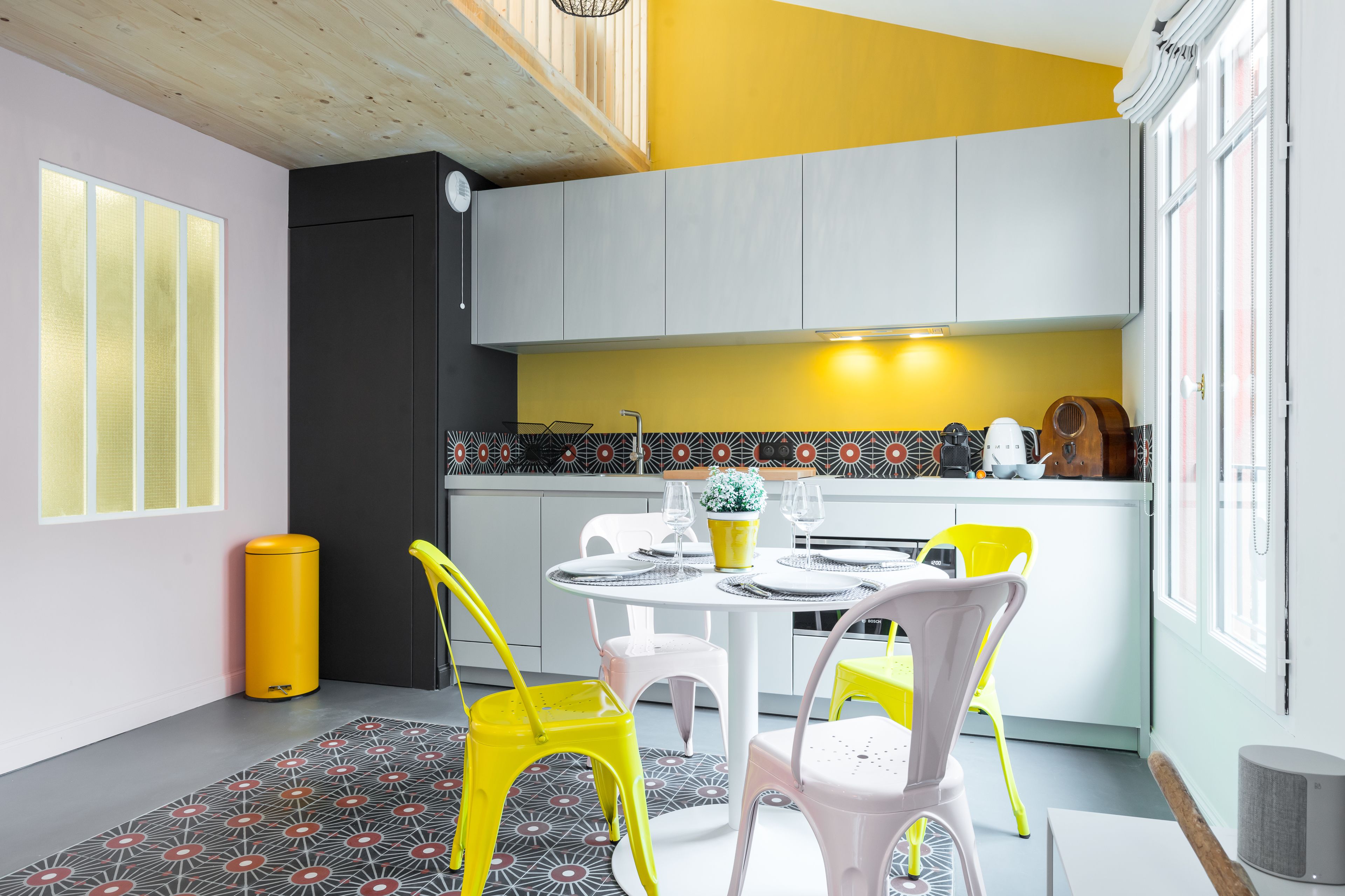 Une cuisine compacte avec un coin repas, comprenant une table ronde, des chaises et une petite plante en pot.