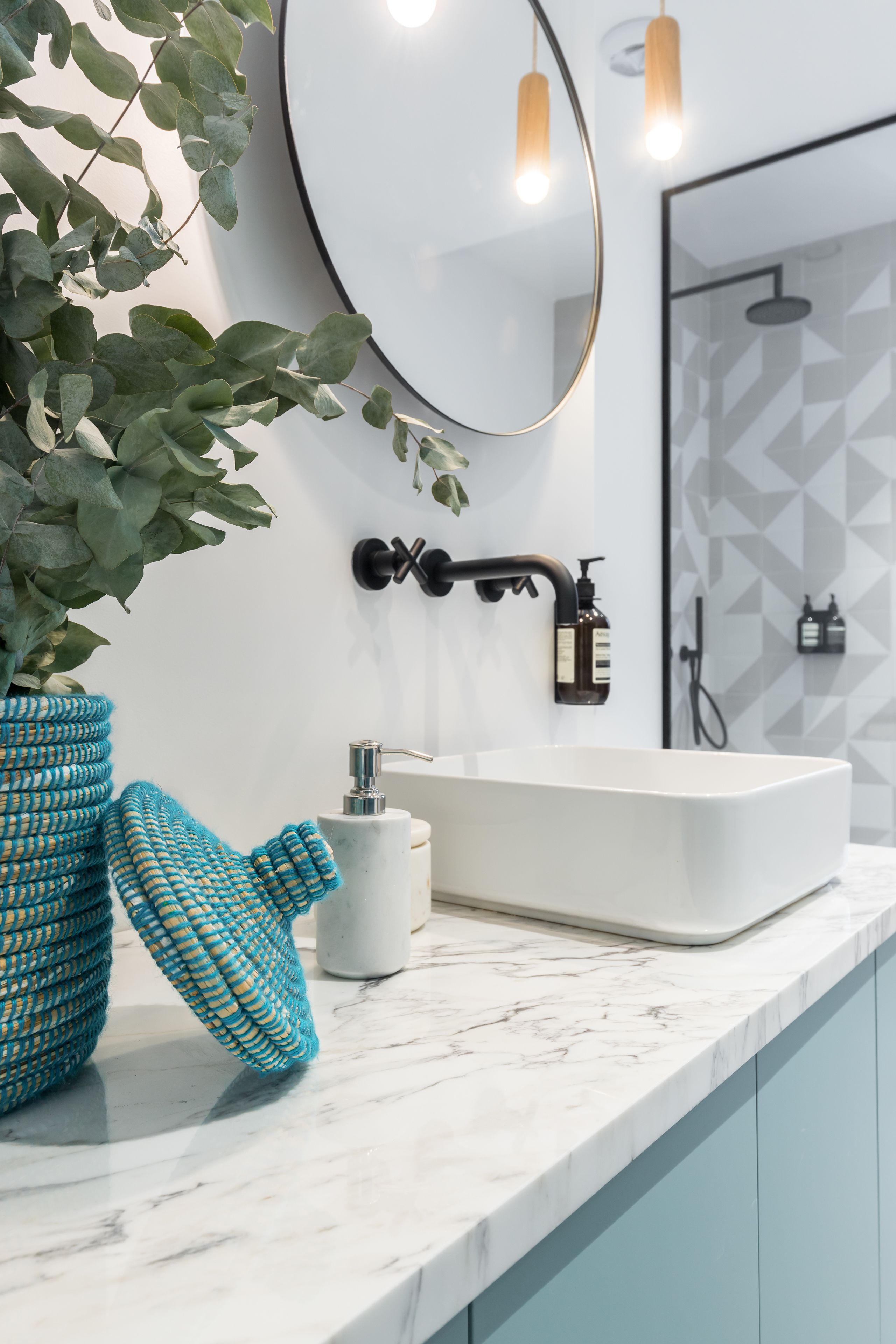 Un bagno con un lavandino bianco, uno specchio e una zona doccia.