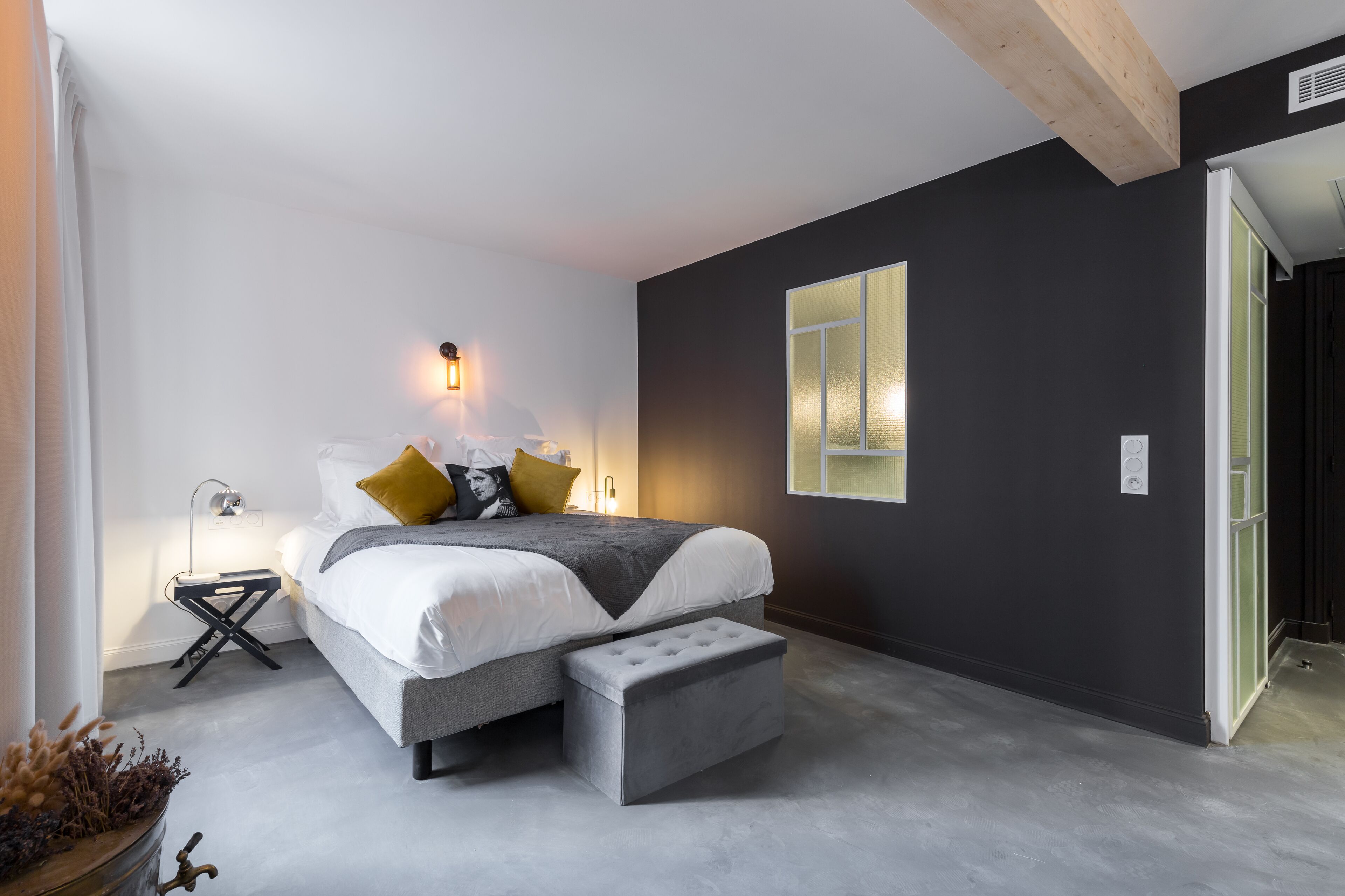 Une chambre moderne avec un lit, une table de chevet et une grande fenêtre.