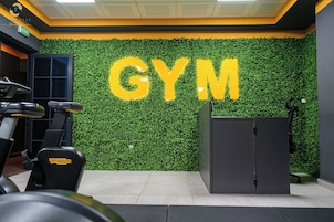 Un gimnasio con una pared verde y la palabra 'GYM' en letras grandes.