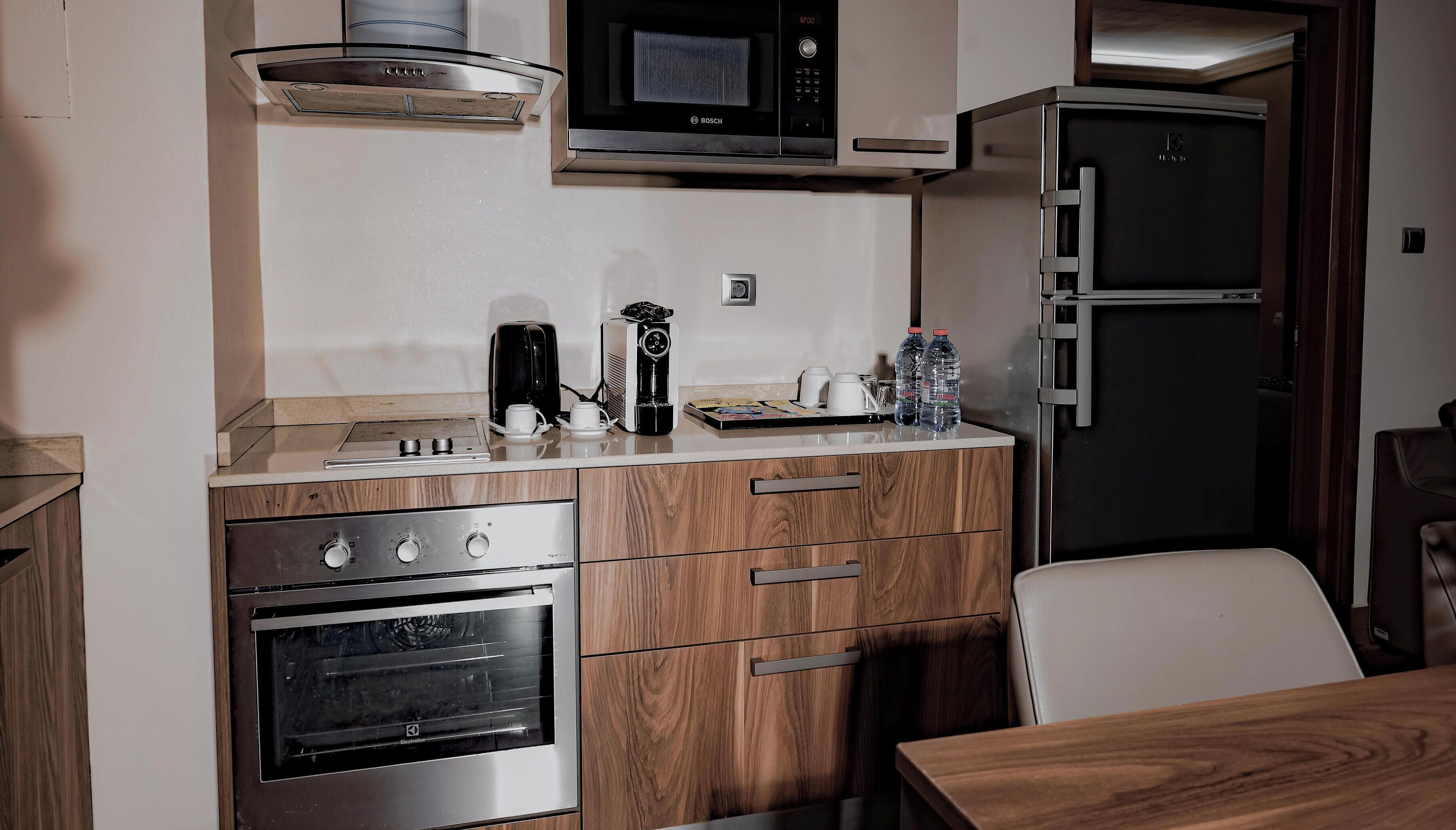 A compact kitchenette with a microwave, a coffee maker, a toaster, and a refrigerator.