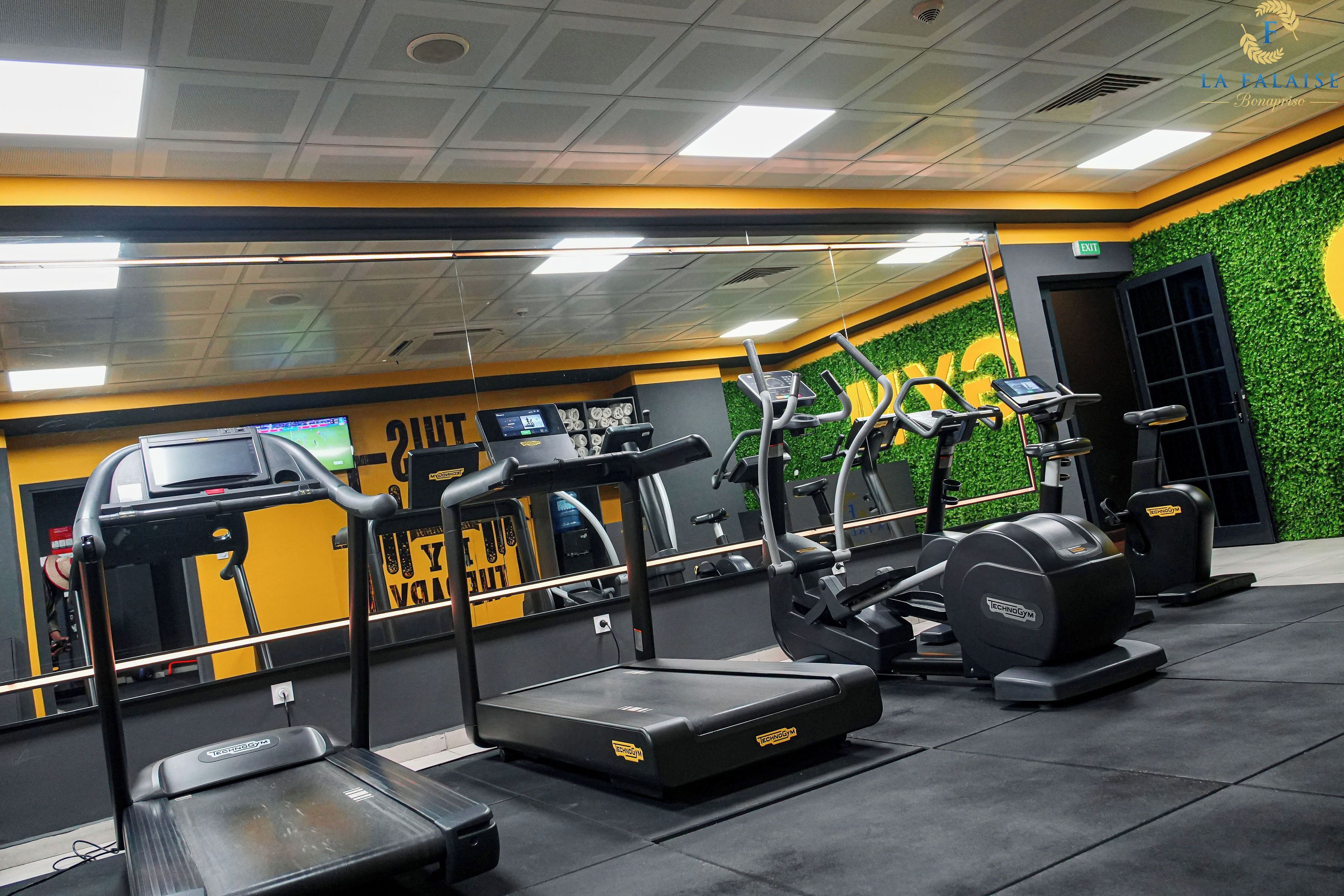 Un gimnasio con cintas de correr, elípticas y equipos de pesas.