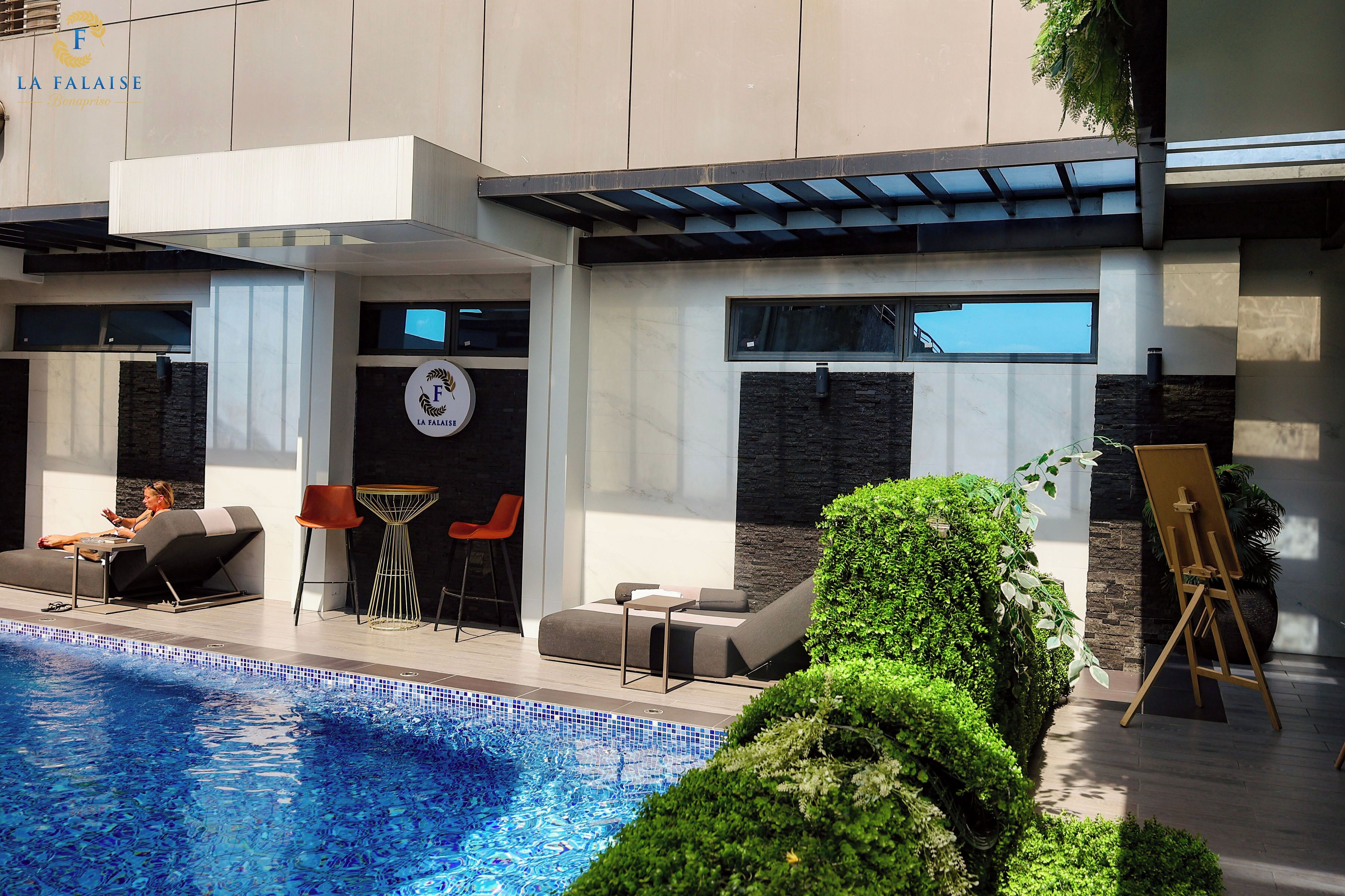 Una piscina al aire libre, sillones reclinables de piscina