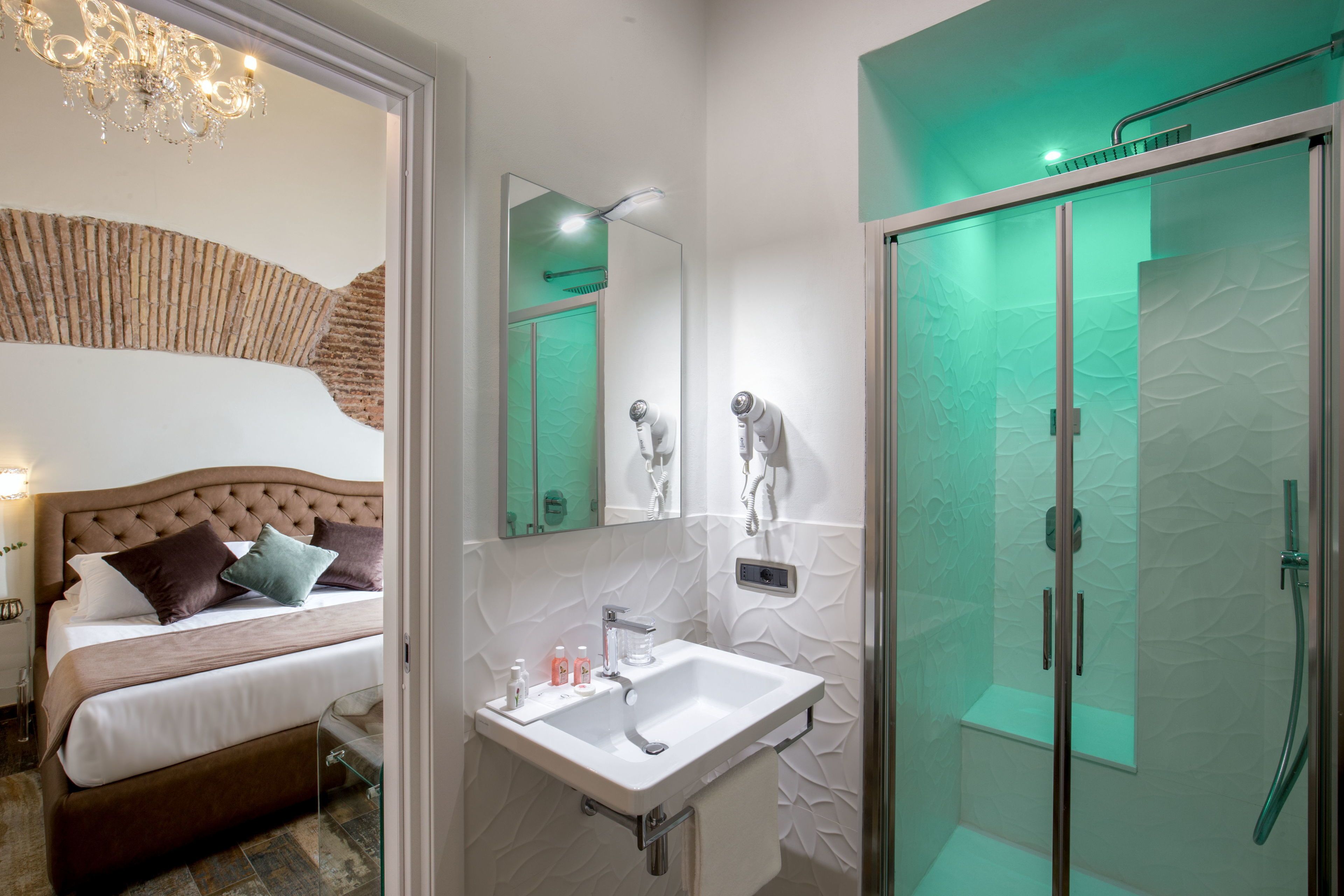 A modern bathroom with a glass-enclosed shower, a white sink, and a large mirror.