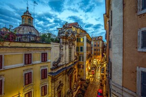 A narrow street flanked by historic buildings with ornate facades and a prominent dome structure. - MySuite Tower Pantheon (Rome)