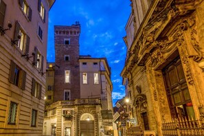 A narrow street with historic buildings, including a tower and ornate facades. - MySuite Tower Pantheon (Rome)