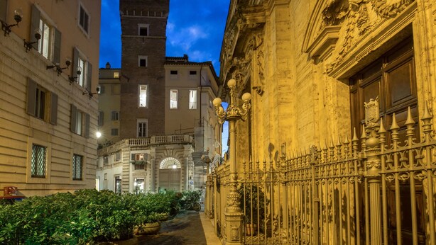 A narrow street with historic buildings, ornate iron gates, and a clear sky. - MySuite Tower Pantheon (Rome)
