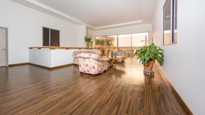 A spacious living area with a wooden floor, a sofa, a coffee table, and a potted plant. - Ayenda Marckia 1901 (Armenia)