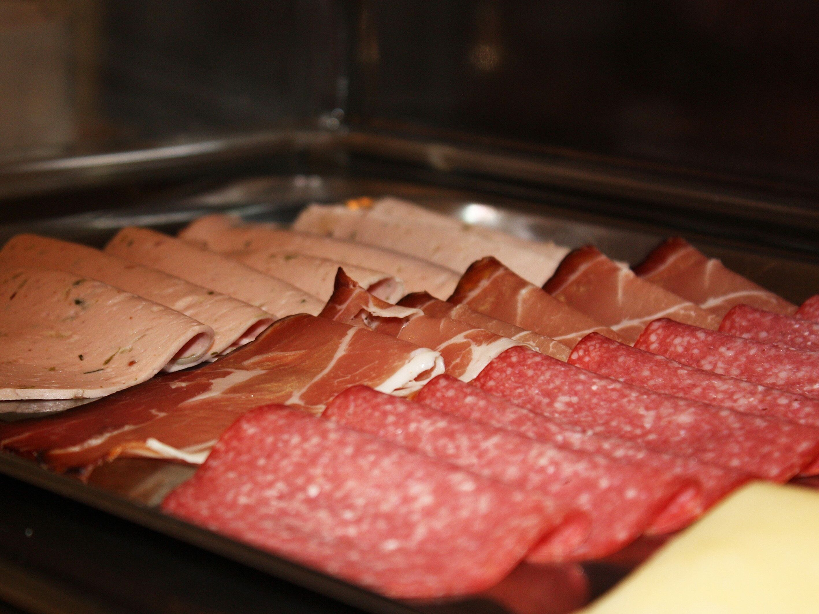 A variety of sliced meats on a tray.