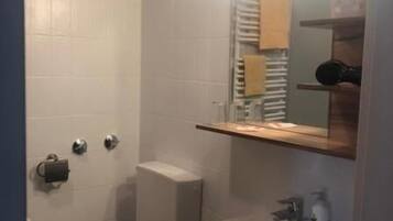 Ein Badezimmer mit Toilette, Waschbecken und Spiegel.