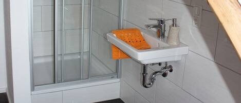 A bathroom with a shower, sink, and toilet.