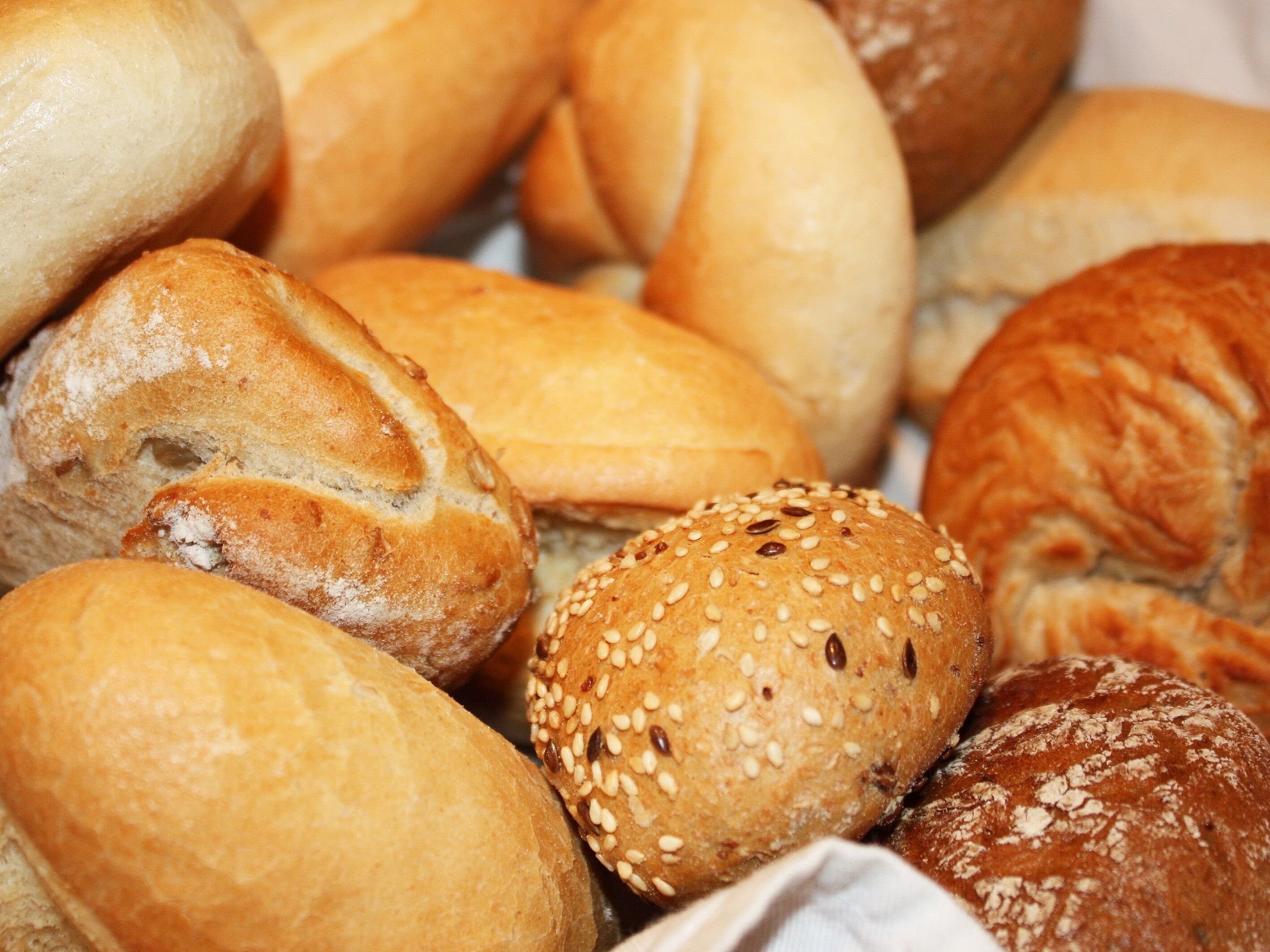 Verschiedene Brötchensorten, darunter Sesambrötchen und einfache Varianten.