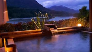A hot tub with a view of a lake and mountains.