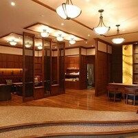 Un interior japonés tradicional con suelo de madera, esteras de tatami y una mesa baja con sillas.