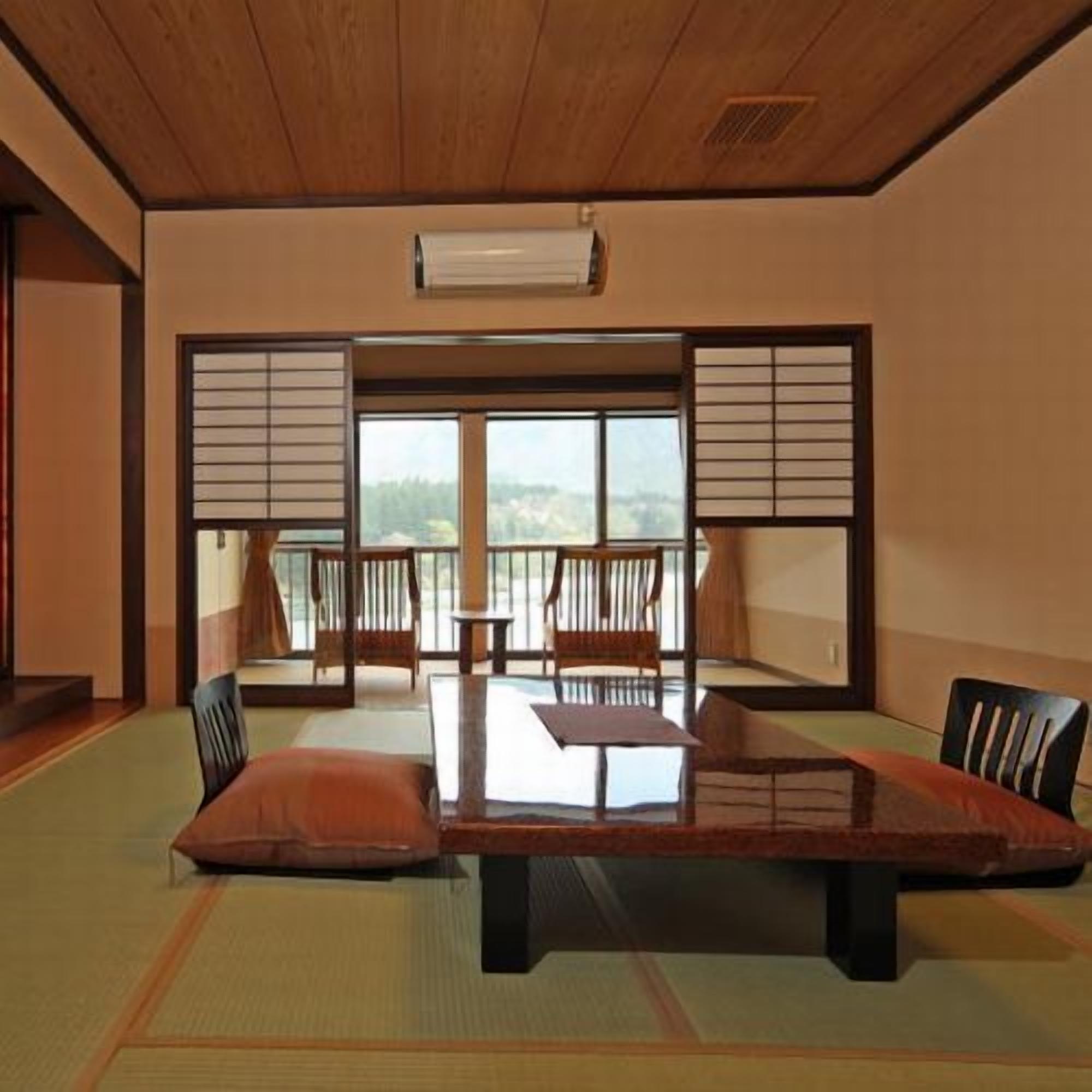 Une pièce de style japonais traditionnel, avec un sol recouvert de tatamis, une table basse et des portes coulissantes.