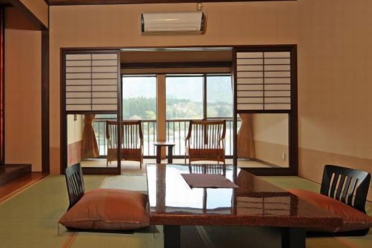 A traditional Japanese room with tatami flooring, a low table, and sliding doors.