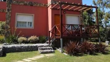 Un edificio rojo con un porche cubierto y escalones de piedra que conducen a una puerta.