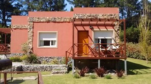 A red building with a stone facade, a balcony with a metal railing, and a small window. - Icalma de la Sierra Apart Hotel Tandil (Tandil)